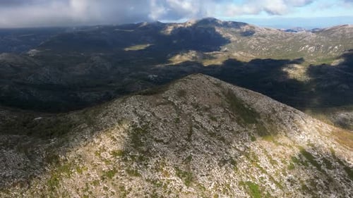A mountain peak is illuminated by the sun. Mountain landscape filmed with a drone. Aerial view.