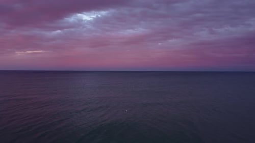 Flying Above the Sea at Sunset with Colorful Clouds Orange