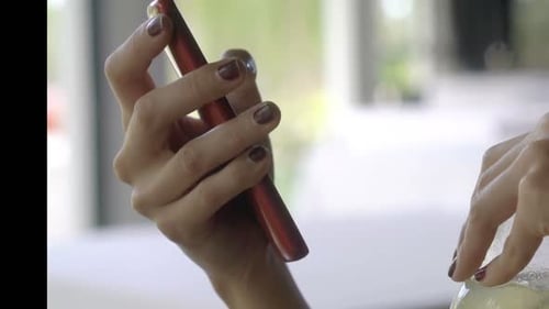 Young Woman Texting on Smartphone and Drinking Cocktail in Cafe 30s