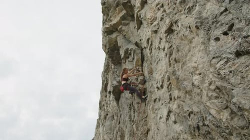 Female Climber Going UpRocky Cliff