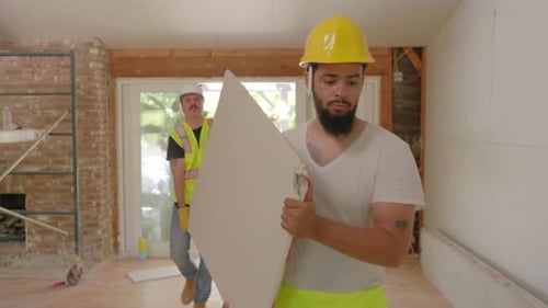 Ein Team verschiedener Bauherren, die gemeinsam an der Renovierung eines Hausprojekts arbeiten