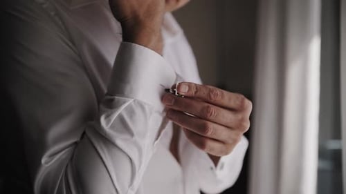 Man Fastens Cufflinks on Elegant White Dress Shirt Man Fastens Cufflinks on Elegant White Dress Shirt