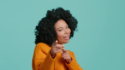 Hey, du, eine Afroamerikanerin, die glücklich in die Kamera zeigt