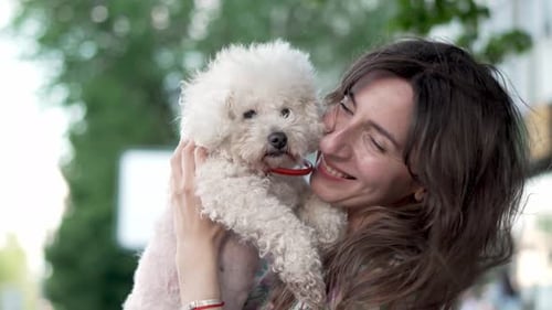 Smiling Woman Hugging a Small White Dog
