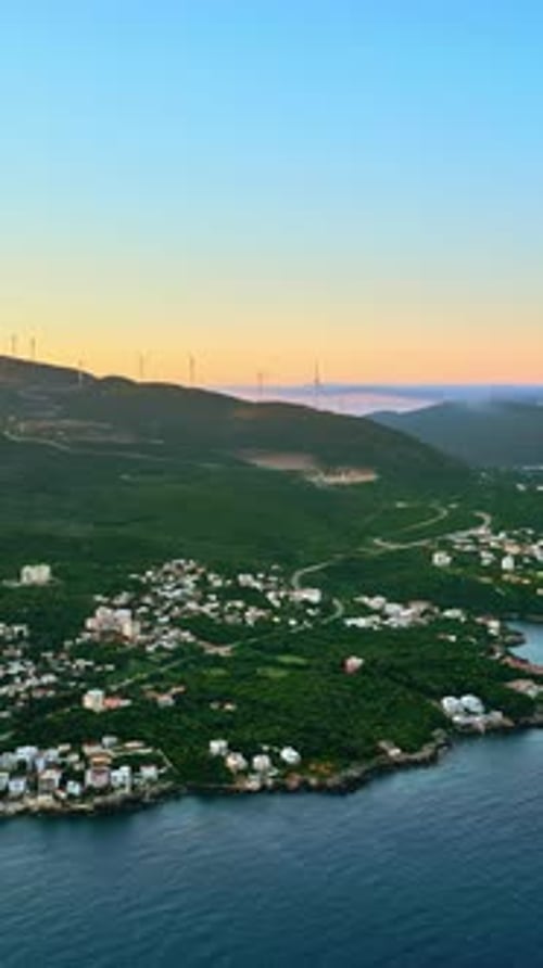 Aerial, drone view of buildings on the shore of the Adriatic sea, with mountains on the background i
