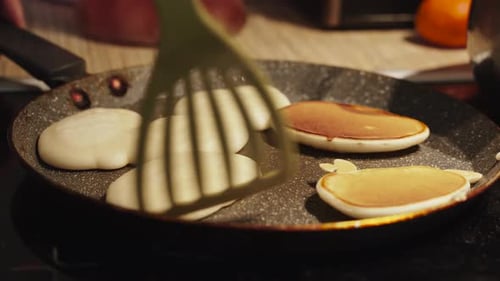 Pancakes Cooking in Pan on Stove Top