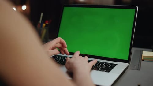 Woman Typing on Laptop with Chroma Key Screen