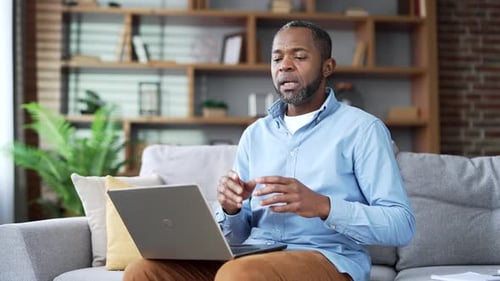 Man Talking on Laptop Video Call on Couch