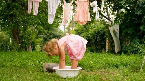 The Child is Washing Clothes in the Garden Selective Focus