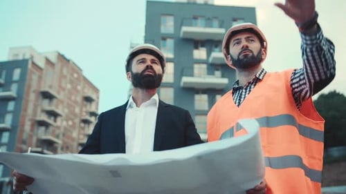 The Builder and Businessman are Discussing the Construction Plan of the Modern Business Center A Man