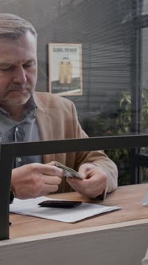 Man at Bank Counting Money and Handing it Over