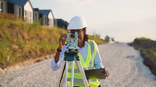 Surveyor Using Theodolite at Construction Site