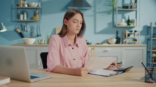 Frustrated Young Woman Accountant Use Calculator to Check Sums in Annual Report