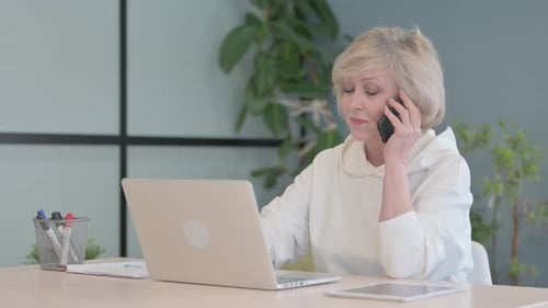 Senior Woman Working and Talking on Cell Phone