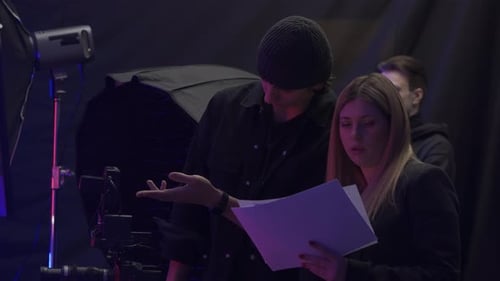 A Female Producer and Videographer Discuss the Storyboard in the Studio Before Filming Meanwhile the