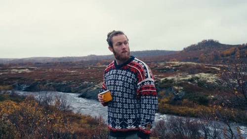 Norwegian Hiker Drinking Coffee Near The River Mountain At Dovrefjell National Park, Norway. Medium
