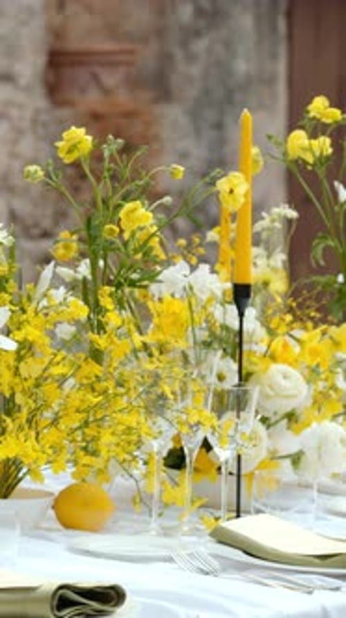 Elegant table setting with yellow flowers and lemons