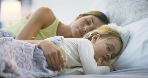 4k video footage of a mother and her little daughter sleeping in bed together at home
