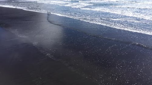 Aerial Slow Motion View of Atlantic ocean Waves Washing Sandy Beach Iceland