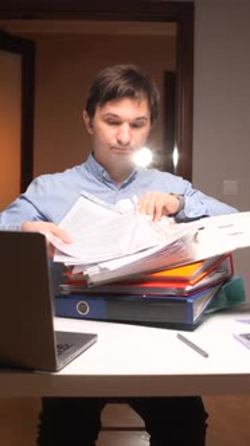 Vertical Video Office Worker Searching Through Stack of Documents at Night