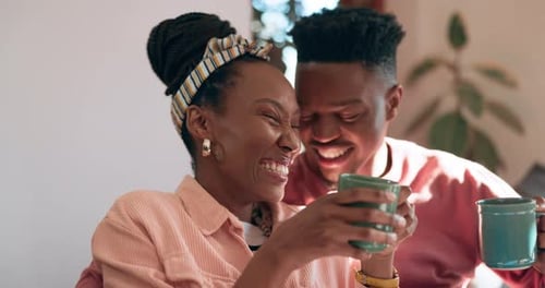 Young Couple Laughing Together at Home with Coffee