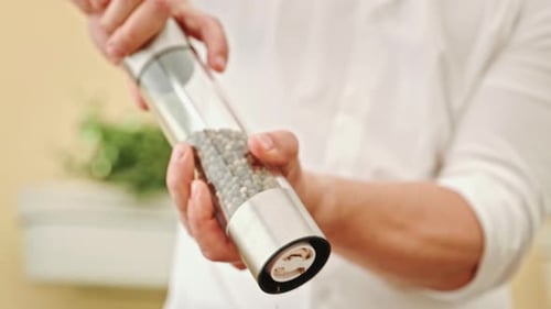 The Cook's Hands with Metal Tongs Carefully Place the Steak on a Wooden Board