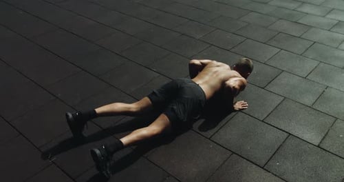 Hombre musculoso haciendo flexiones afuera