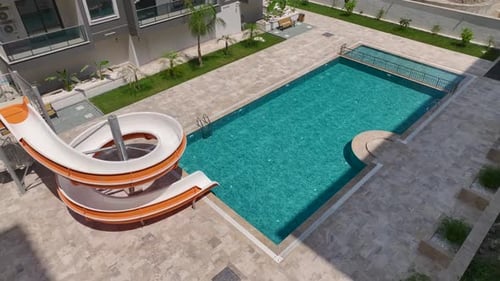 Aerial View Pool With a Slide Kids Splashing and Having Fun