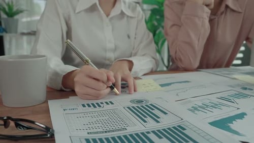 Deux jeunes femmes d'affaires enthousiastes travaillent ensemble dans l'espace de travail du bureau.