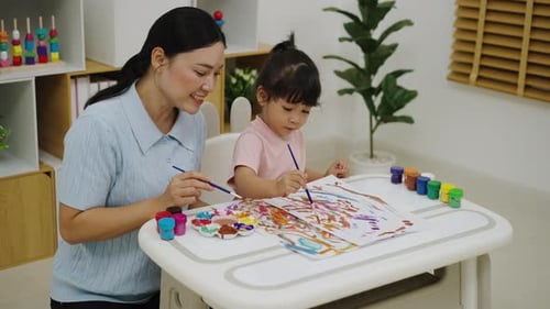 Mother and child painting together indoors at home