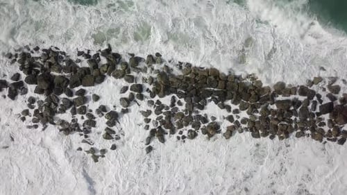 Ocean Waves Crashing on Rocky Shoreline, Aerial View
