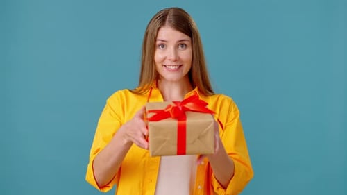 Woman Presents Gift with Red Ribbon on Blue Background