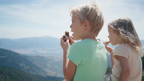 Children Eating Snack Energy Bar on Beautiful Mountain Landscape at Hiking Trip