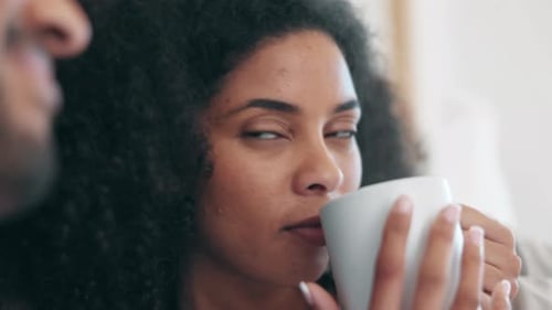 Woman Smiles at Boyfriend While Drinking Beverage