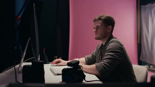 Digital Photographer Editing Photos on PC in Professional Studio