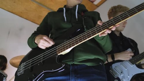 close-up of two teenage guitarists in a house rock band