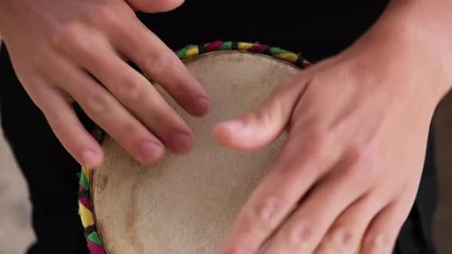 Hände eines Musikers, der in Kalabrien eine Trommel zwischen seinen Beinen spielt