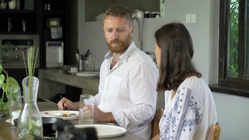 Couple eating breakfast together at home at table