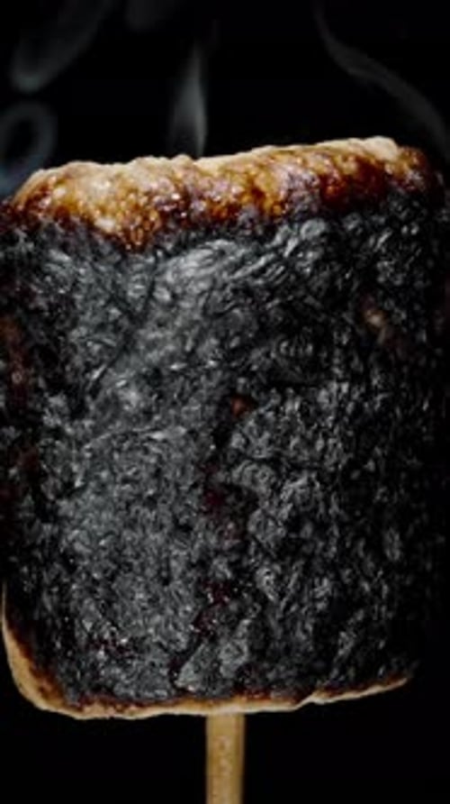 Vertical video. Marshmallow on Stick Burning, Covered with Black Crust, Sugar Bubbling and Smoking.