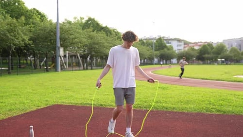 Young Adult Jumps Rope in Urban Park