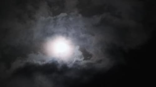 Moon Shines Brightly Through Swirling Dark Clouds