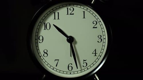 The alarm clock on a black background, in the style of time-lapse video.