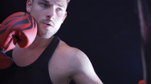 Man Punches Heavy Bag During Fitness Training