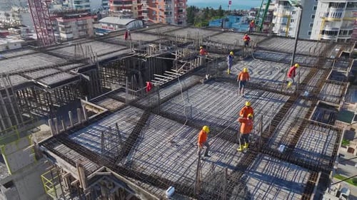 Vidéo aérienne d'un projet immobilier dans lequel des ouvriers du bâtiment font fonctionner des machines et posent des briques