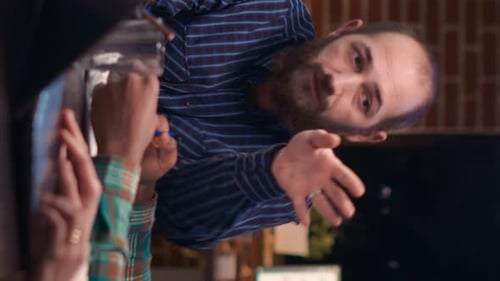 Man Talking and Gesturing with Friends at Bar