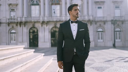 Man in Tuxedo Standing Before Grand Building