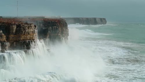 Massive Ocean Waves Crashing Against Rugged Cliffs Creating an Explosion of White Foam Under a