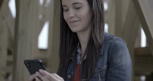 Nahaufnahme einer Frau, die draußen an der Treppe surft und auf ihrem Handy eine SMS schreibt