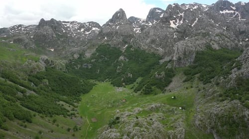 Flying over a mountain village in the Alps against the backdrop of epic beautiful rocks. Aerial view