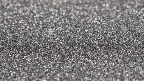 Macro slide shot, small silver sequins, shimmer in the light